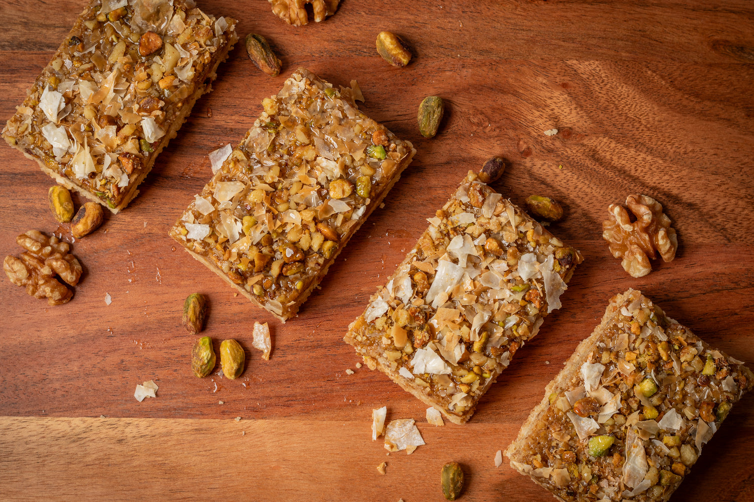 Decadent dessert bar with a buttery shortbread crust, layered with walnuts, pistachios, and flaky phyllo dough, offering a delightful twist on classic baklava in a convenient bar form
