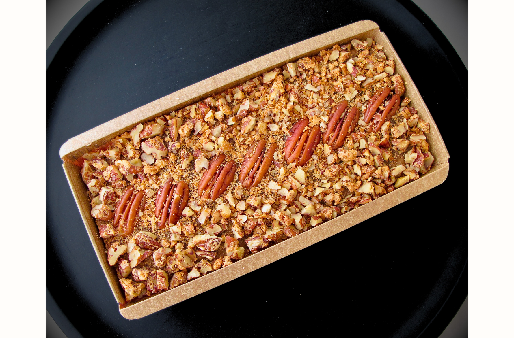 Rich and festive fruitcake packed with dates, raisins, cranberries, walnuts, praline pecans, and a hint of rum, offering a perfect blend of fruity sweetness, nutty crunch, and warm, spiced flavors