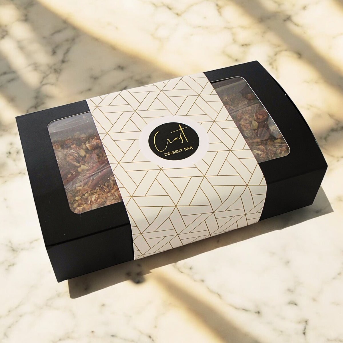 Medley fruitcake packaged in a black box with sleeve and craft dessert bar logo