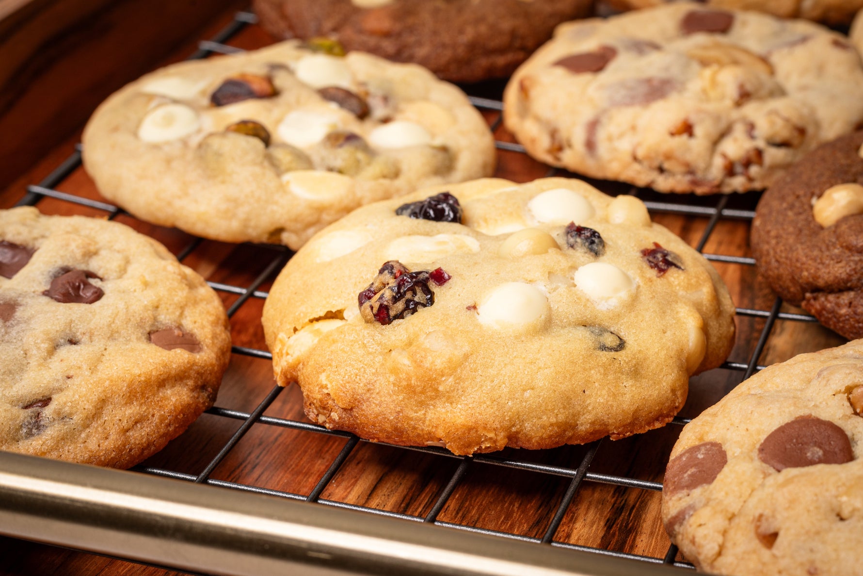 Assorted gourmet cookies featuring a variety of flavors and textures, including classic chocolate chip, pistachio cookie, coffee cookie, hazelnut cookie, macadamia and white chocolate cookie, oats and dark chocolate cookie, walnut milk chocolate cookie, perfect for any sweet craving