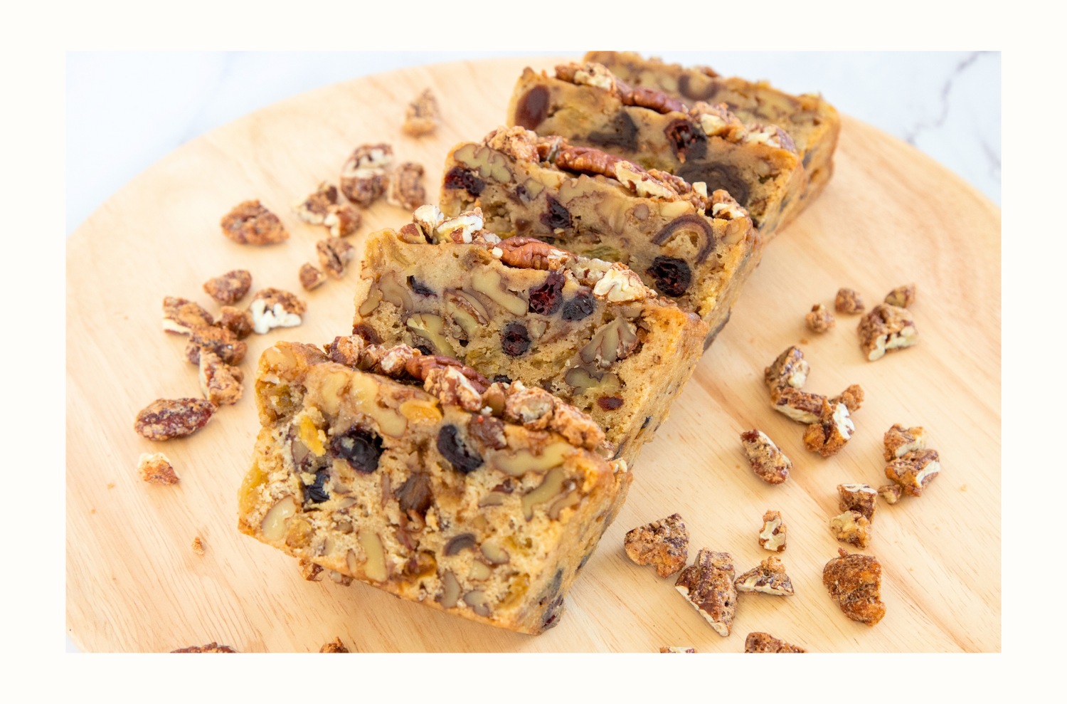 Luxurious rum-infused fruitcake bursting with dates, raisins, cranberries, walnuts, and praline pecans, offering a moist, flavorful treat with a perfect blend of sweetness and spice.